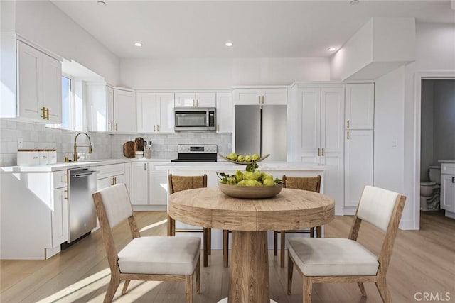 kitchen featuring tasteful backsplash, sink, white cabinets, and appliances with stainless steel finishes