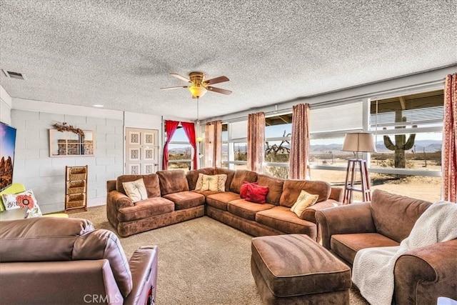 carpeted living room with ceiling fan and a textured ceiling