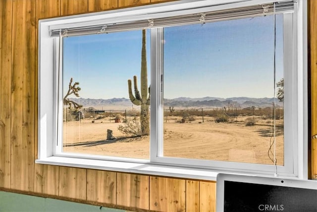 doorway to outside with a mountain view and wood walls