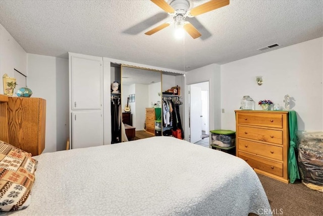 carpeted bedroom with ceiling fan, a textured ceiling, and a closet