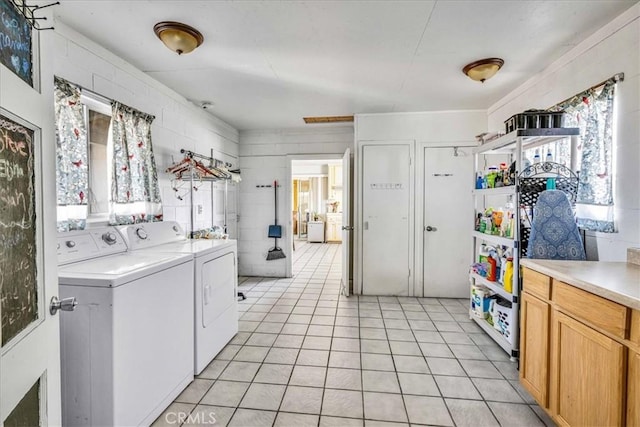 laundry room with washer and clothes dryer and light tile patterned flooring