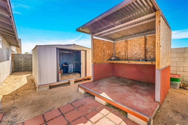 view of patio featuring a storage unit