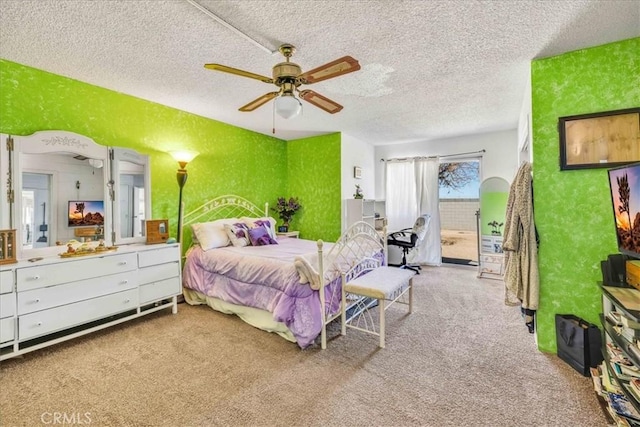 carpeted bedroom featuring ceiling fan and a textured ceiling