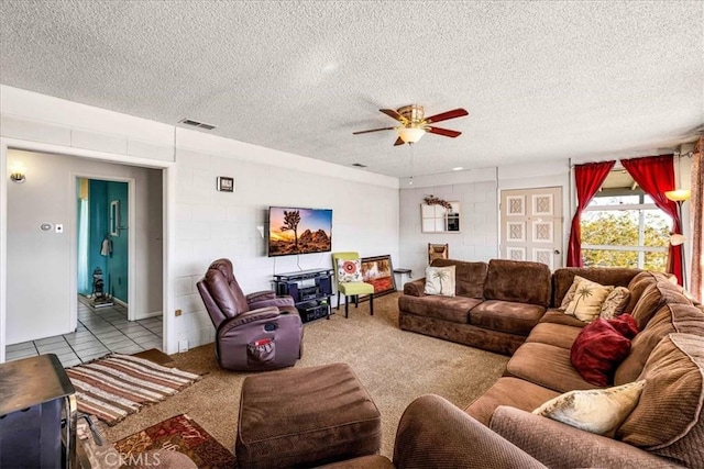 living room with ceiling fan, light tile patterned floors, and a textured ceiling