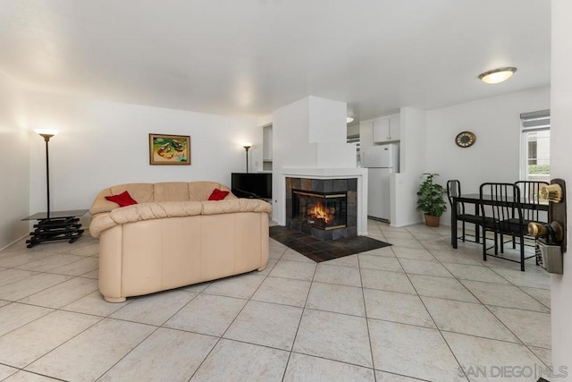 living room featuring a tile fireplace and light tile patterned floors