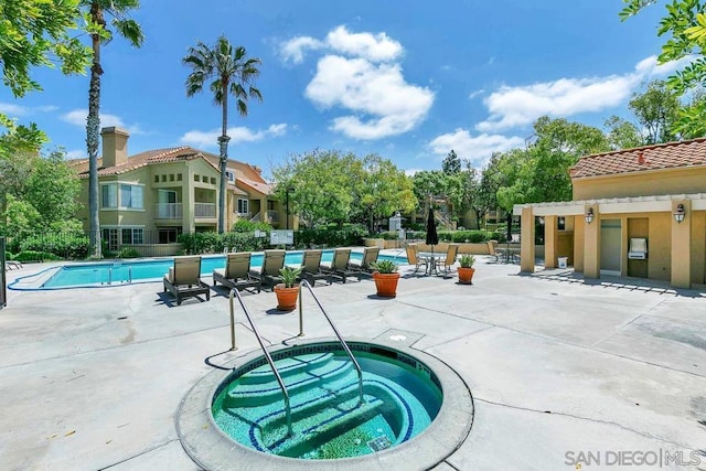 view of swimming pool with a community hot tub and a patio area