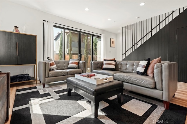 living room featuring recessed lighting, wood finished floors, and stairs