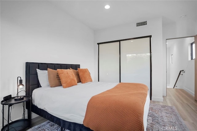 bedroom with baseboards, visible vents, light wood-type flooring, a closet, and recessed lighting