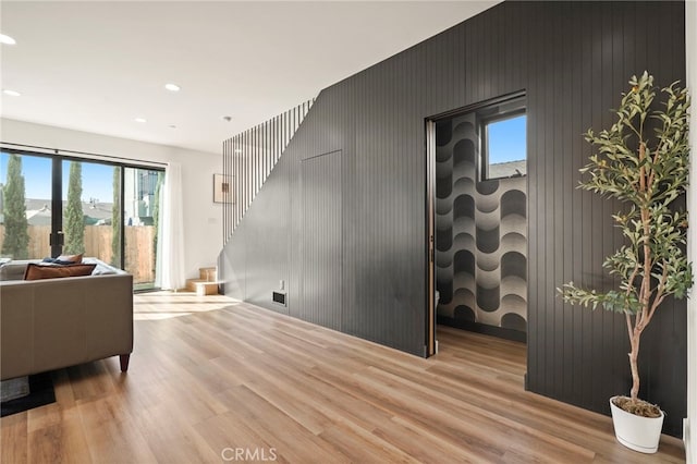 living area with light wood-style floors, stairway, and recessed lighting