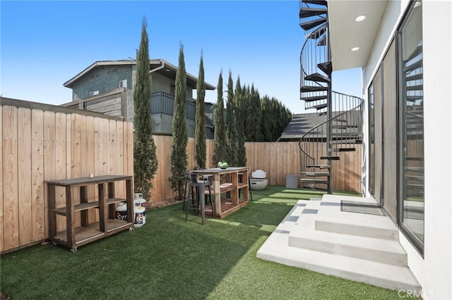 view of yard featuring a fenced backyard and stairway