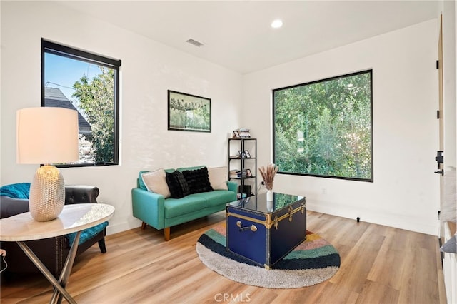 sitting room featuring light wood-style floors, plenty of natural light, and visible vents