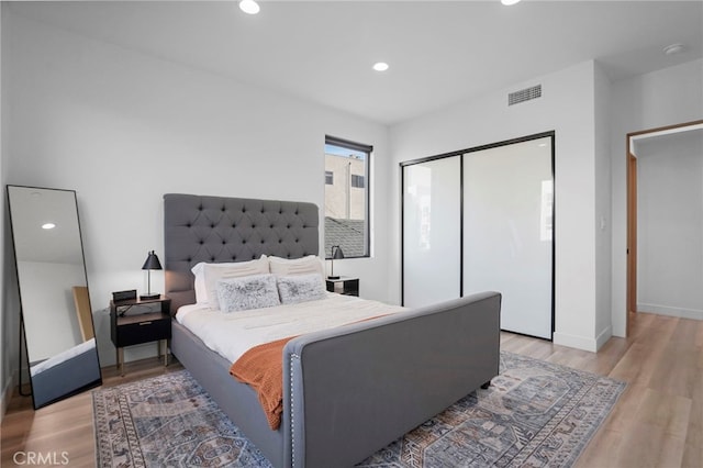 bedroom featuring light wood finished floors, a closet, visible vents, and recessed lighting