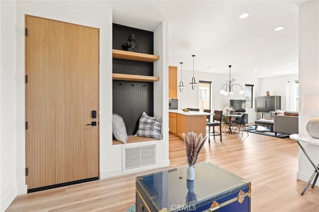 living area with recessed lighting, visible vents, baseboards, light wood finished floors, and an inviting chandelier