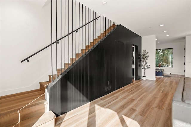 staircase featuring recessed lighting, baseboards, and wood finished floors