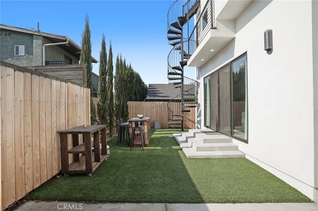 view of yard with entry steps, fence, and stairs