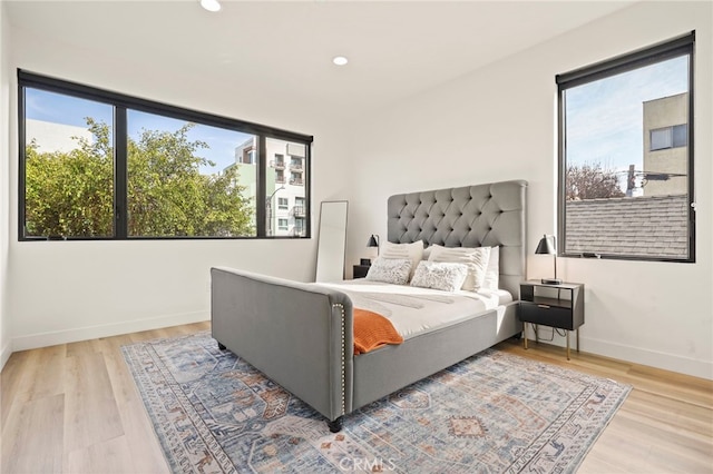 bedroom with multiple windows, recessed lighting, wood finished floors, and baseboards