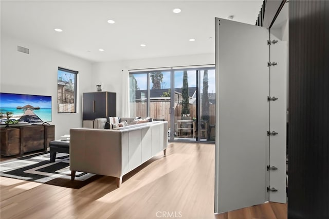 living area with recessed lighting, visible vents, and light wood-style flooring