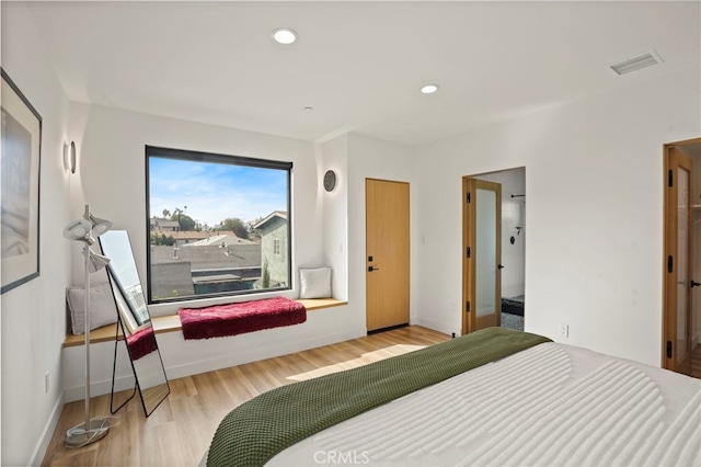 bedroom featuring baseboards, visible vents, wood finished floors, and recessed lighting