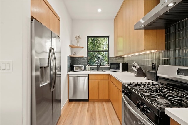 kitchen featuring light countertops, appliances with stainless steel finishes, extractor fan, and backsplash