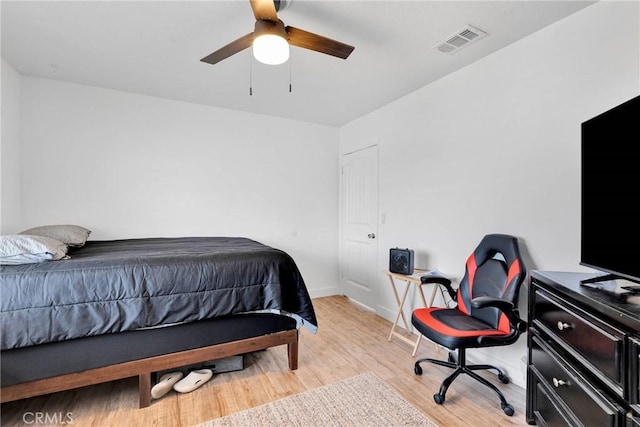 bedroom featuring light wood-type flooring, baseboards, visible vents, and ceiling fan