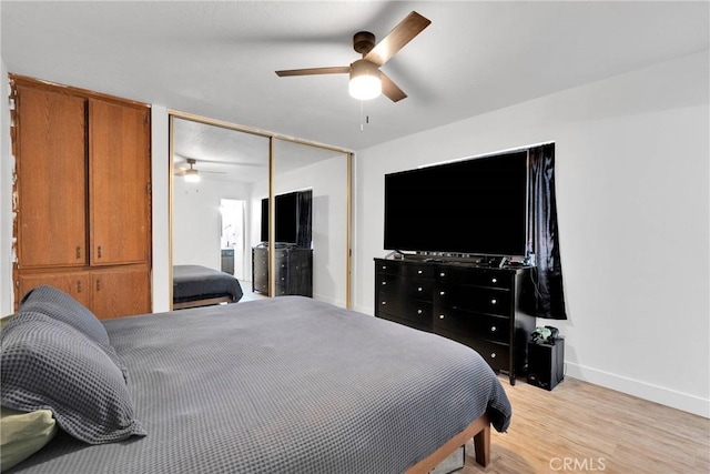 bedroom featuring ceiling fan, light wood finished floors, a closet, and baseboards