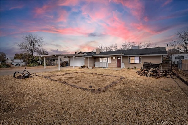 single story home with driveway, fence, and a carport