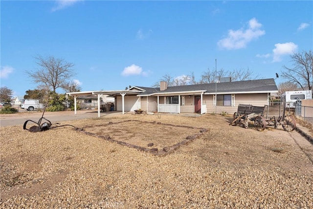 ranch-style house with driveway, fence, and an attached carport