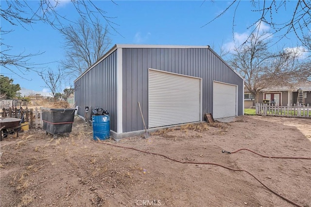 detached garage featuring fence