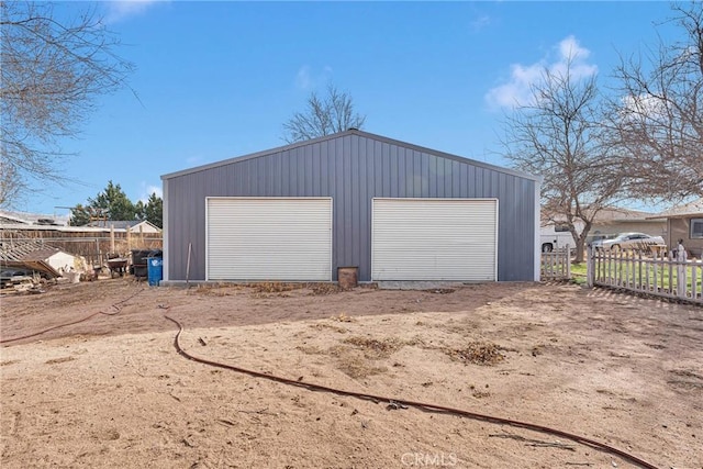 detached garage featuring fence