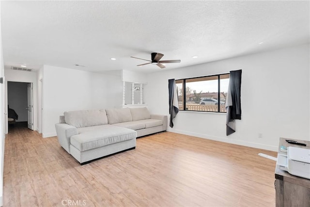 living room with baseboards, visible vents, and light wood finished floors