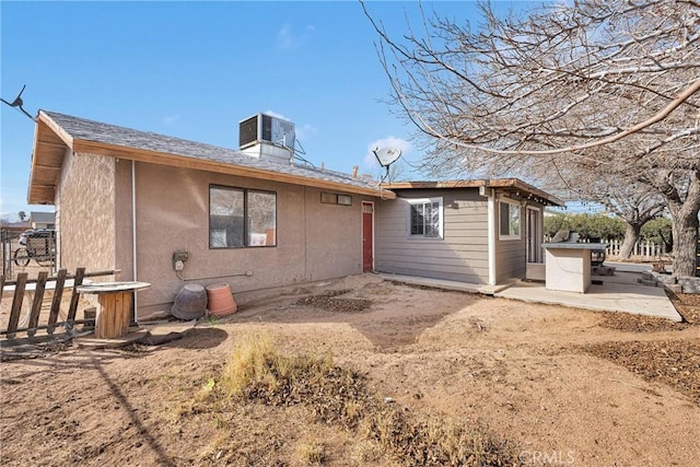 rear view of property featuring cooling unit, a patio area, fence, and stucco siding