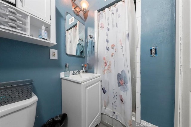 bathroom featuring vanity, toilet, and walk in shower