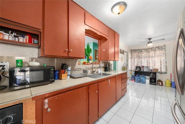 kitchen with sink, light tile patterned floors, stainless steel fridge, and ceiling fan