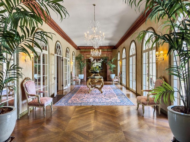 interior space featuring ornamental molding, parquet floors, an inviting chandelier, and french doors