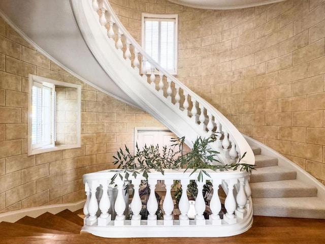 stairs featuring crown molding, vaulted ceiling, and wood-type flooring