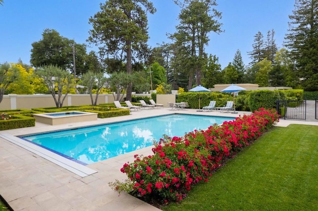 view of swimming pool with an in ground hot tub, a yard, and a patio area