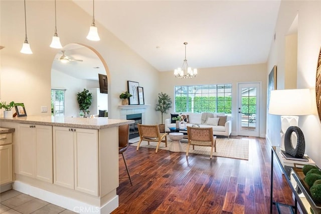 kitchen with white cabinetry, light stone countertops, dark wood-type flooring, and hanging light fixtures