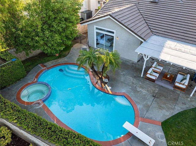 view of pool featuring a patio area, a diving board, and an in ground hot tub