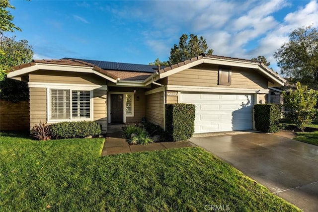 single story home with a garage, a front lawn, and solar panels