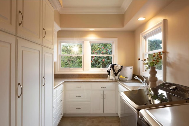 laundry room featuring cabinets, crown molding, separate washer and dryer, and sink