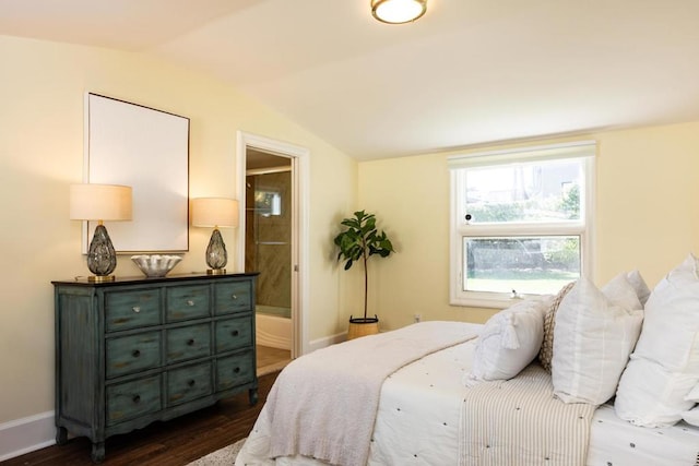 bedroom with connected bathroom, dark hardwood / wood-style flooring, and vaulted ceiling