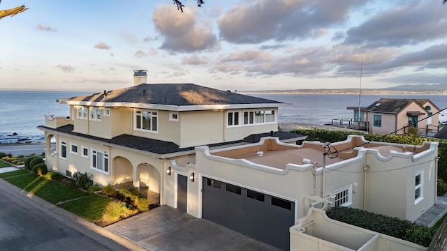 view of front of house featuring a garage and a water view