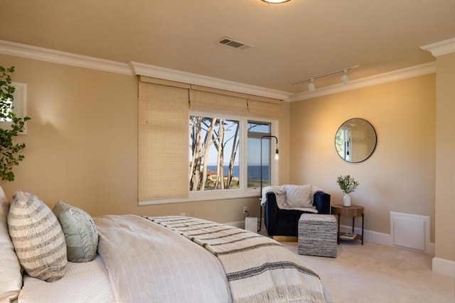 carpeted bedroom with track lighting and ornamental molding