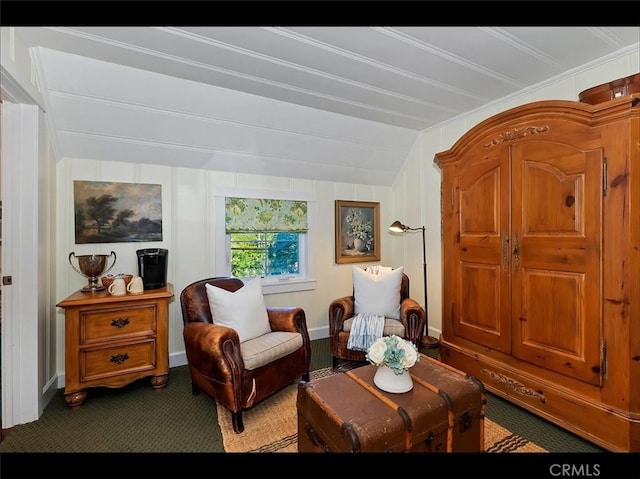 sitting room with vaulted ceiling and dark carpet