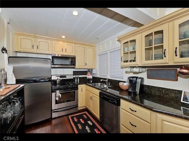 kitchen with stainless steel appliances, dark hardwood / wood-style floors, sink, and dark stone countertops