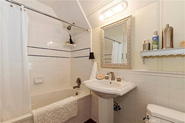 bathroom featuring shower / tub combo with curtain, tile walls, and toilet