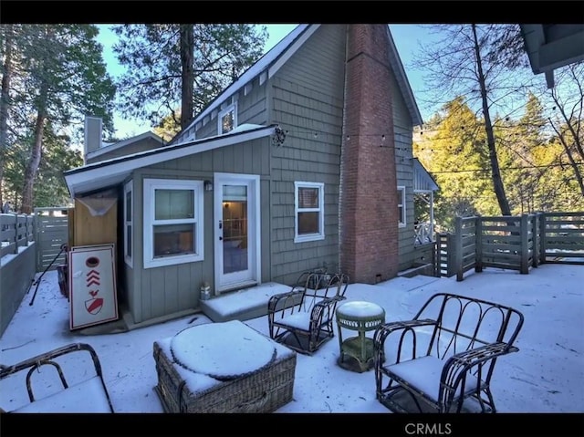 view of snow covered back of property