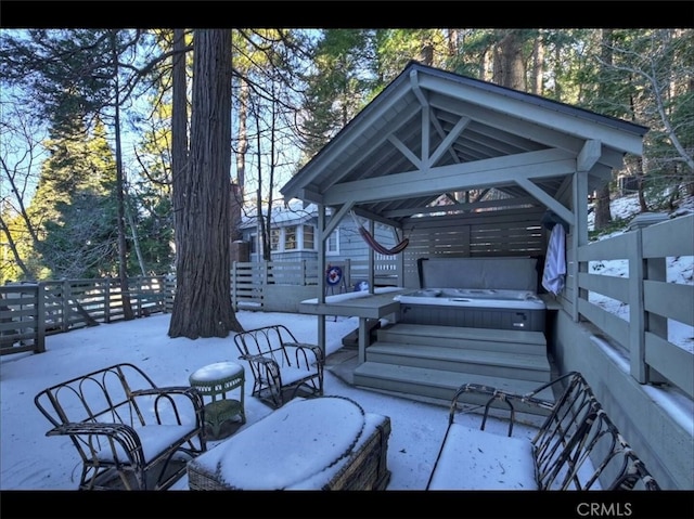 wooden terrace featuring a hot tub, a gazebo, and a patio