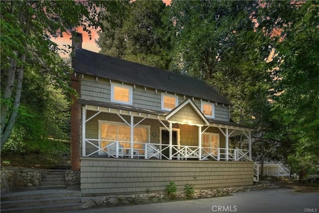 outdoor structure at dusk featuring covered porch