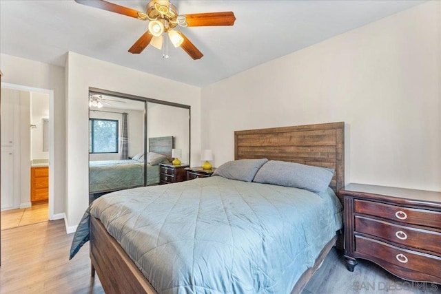 bedroom with ceiling fan, light wood-type flooring, and a closet